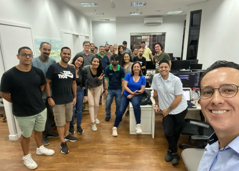 Grupo de participantes de uma apresentação educativa sobre planejamento financeiro em uma empresa, com Lenilson Gabriel em primeiro plano